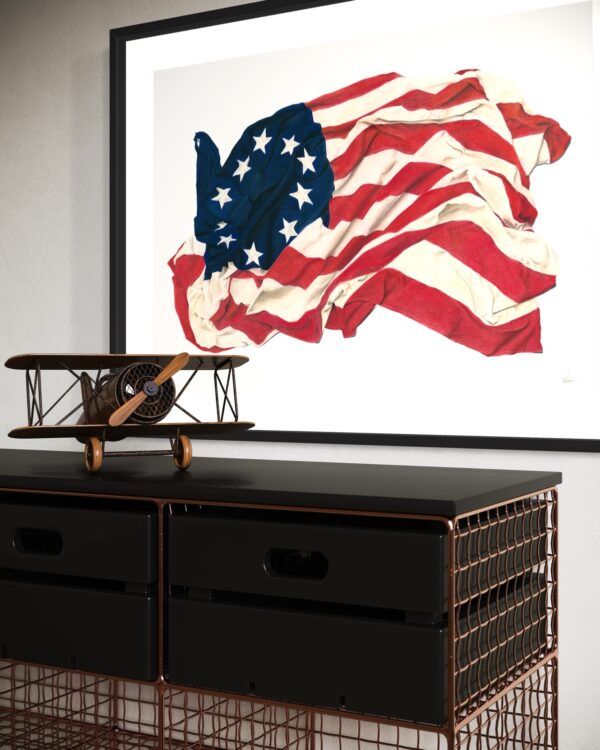 Framed Betsy Ross flag art print displayed on a wall, featuring the detailed colored pencil drawing of the historic flag