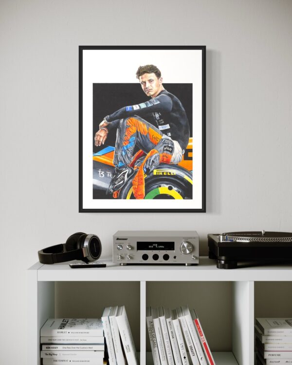 Framed Lando Norris art print displayed on a wall, capturing the detailed colored pencil drawing of the Formula 1 driver sitting on his car